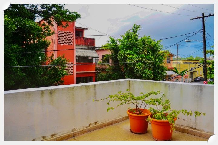 Image of a balcony with a solid wall enclosure.  A person seated on this balcony would be well screened from the street below.  Naan Design.  Naandesign.