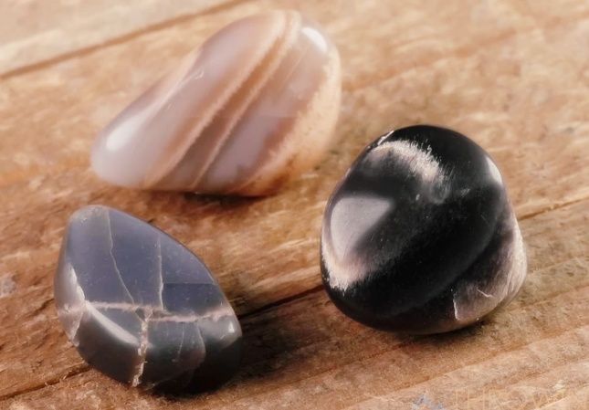 Grey, black and peach moonstones on a table